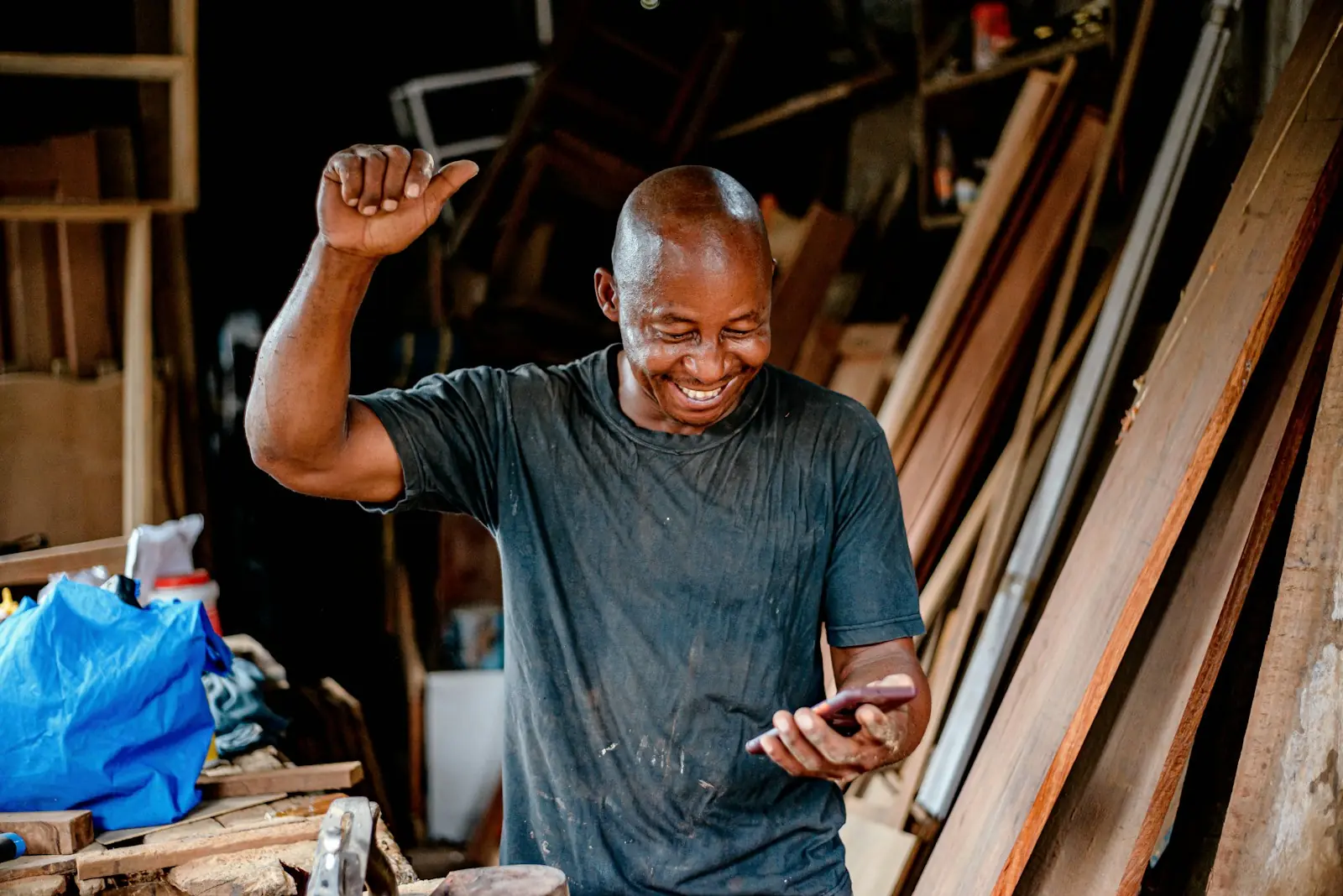 A carpenter celebrating in his workshop